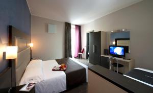 a hotel room with a bed and a television at Hotel Five in Milan