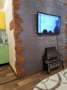 a living room with a tv on a wall at Стильная студия в центре г Норильска Ленинский проспект 27 in Noril'sk