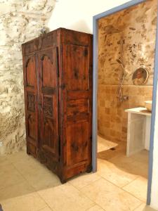 une ancienne armoire en bois dans une chambre avec salle de bains dans l'établissement La Magnanerie d'Audabiac, à Lussan