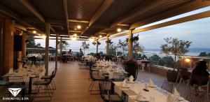 a restaurant with tables and chairs on a balcony at Diamond Hill Resort & SPA in Vlorë