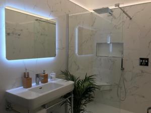 een witte badkamer met een wastafel en een douche bij Luxurious Townhouse in the Heart of Champagne in Épernay