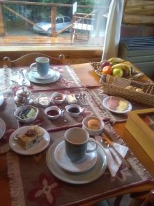 un tavolo con tazze e piatti di cibo sopra di El Aleph a Villa La Angostura