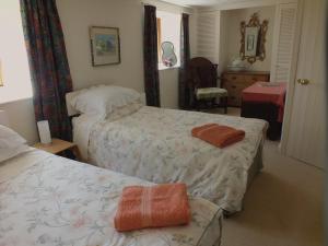 a hotel room with two beds and a chair at Herb Cottage in Bradford on Avon