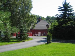 a red barn with a street light in the grass at Poeme A SANDEFJORD in Kodal