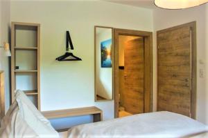 Schlafzimmer mit zwei Holztüren und einem Spiegel in der Unterkunft Living Apartment Maurer in Sautens