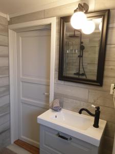 uma casa de banho com um lavatório branco e um espelho. em Poeme A SANDEFJORD em Kodal
