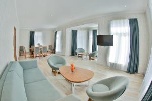 ein Wohnzimmer mit einem Sofa, Stühlen und einem Tisch in der Unterkunft Yurd Hotel in Qax