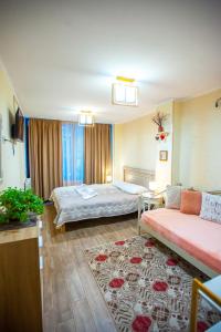 een hotelkamer met 2 bedden en een bank bij Apartments Beautiful Tbilisi on L.Meskhishvili Turn 1 in Tbilisi City