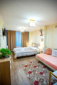 a hotel room with two beds and a couch at Apartments Beautiful Tbilisi on L.Meskhishvili Turn 1 in Tbilisi City