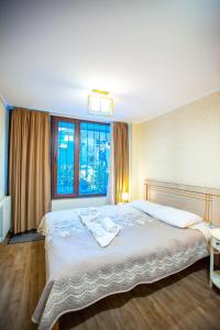 a bedroom with a large bed and a window at Apartments Beautiful Tbilisi on L.Meskhishvili Turn 1 in Tbilisi City