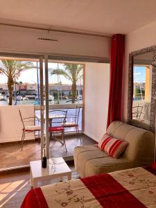 a living room with a couch and a balcony with a table at Cap Capistol Studio le Cap d'Agde vue port in Cap d'Agde