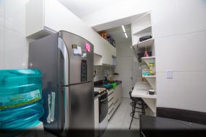 uma cozinha com um frigorífico de aço inoxidável num quarto em Curitiba Central Hostel em Curitiba