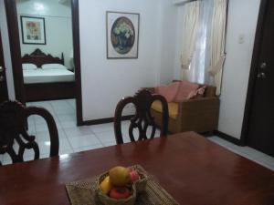 a dining room table with a basket of fruit on it at Casa Micarosa Hotel in Manila