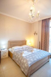 a bedroom with a large bed and a chandelier at Beautiful Tbilisi on Meskhishvili Turn in Tbilisi City +17 photos