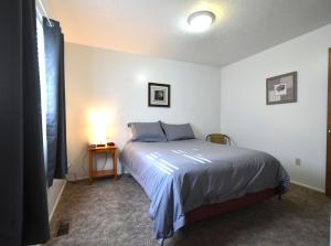 a bedroom with a bed and a table with a lamp at Top of the Town Vacation Home Rental in Lava Hot Springs