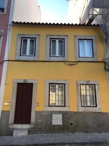 żółty dom z oknami i drzwiami w obiekcie Belém 25, duplex apartment w Lizbonie
