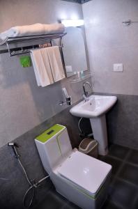 a small bathroom with a toilet and a sink at Marinha Airport Hotel in Kathmandu