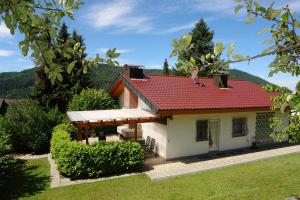 una piccola casa bianca con tetto rosso di Schwarzwälder Ferienwohnungen a Seelbach