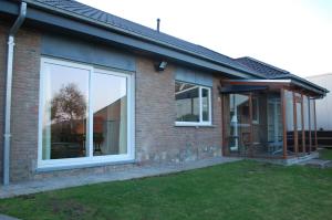 a brick house with a large sliding glass door at Hoppernachten in Zele