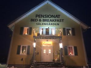 a white house with a sign on the front of it at Sälengården in Vörderås