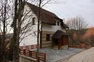 uma pequena casa branca com um telhado castanho em Vila Lucky Kop & Restoran em Kopaonik