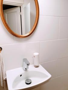 a bathroom with a white sink and a mirror at Koege Guesthouse in Køge