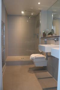 a bathroom with a toilet and a sink and a shower at 19 Ocean Gate in Newquay