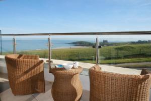 balcone con tavolo, sedie e vista sull'oceano di 19 Ocean Gate a Newquay