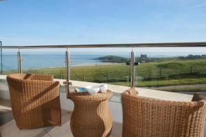a balcony with a table and chairs and the ocean at 19 Ocean Gate in Newquay