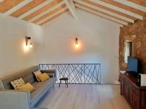 Una sala de estar con un sofá y un televisor. en River House Sejães, en Oliveira de Frades