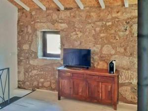 a living room with a television on a wooden cabinet at River House Sejães in Oliveira de Frades