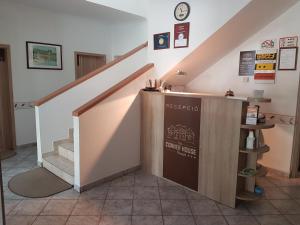 a staircase with a counter in a room with a stair case at The Corner House Panzió in Tata