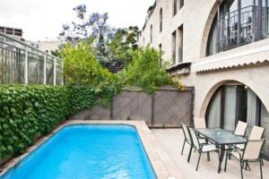 basen ze stołem i krzesłami obok budynku w obiekcie Mamilla Pool - David's Village - Jerusalem-Rent w Jerozolimie