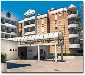 a large building with a parking lot in front of it at Residence Nettuno in Campomarino