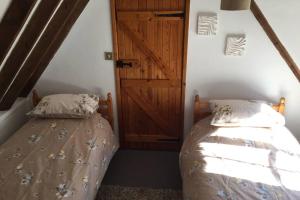 een slaapkamer met een bed en een houten deur bij Rose Cottage in Ludham
