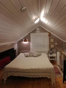 a bedroom with a large bed in a attic at Silfvastas Holiday Homes in Lapinjärvi