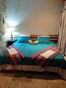 a bedroom with a bed with blue pillows at Santa Gertrudis in El Rancho