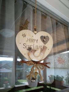 un corazón de madera colgando en una ventana con las palabras "primavera feliz" en Mama vendégház - Palkonya, en Palkonya