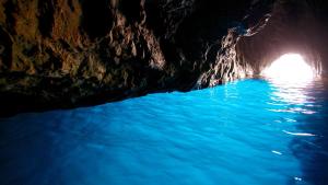 a dark cave with blue water in it at Luna Caprese Guest House in Anacapri +10 photos