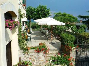un patio esterno con ombrellone, sedie e fiori di Villa Cristina a Castellina in Chianti