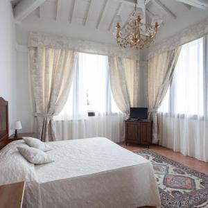 a bedroom with a large bed and a chandelier at Villa Cristina in Castellina in Chianti