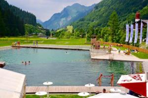 a swimming pool with people in the water at Haus Wallner in Klösterle am Arlberg +24 photos