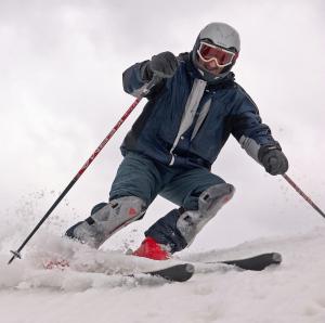 ヤフロマにあるSport Park Volenの雪に覆われた坂道をスキーしている男