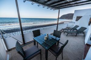 eine Terrasse mit Tisch und Stühlen sowie Strand in der Unterkunft Tito´s Beach House in Pozo Negro