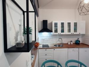 a kitchen with white cabinets and a sink at Goreta032 Apartment in Vukovar