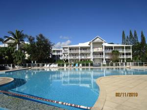 a large swimming pool in front of a large building at Le Mabouya in Saint-François