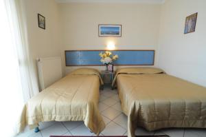 two beds in a hotel room with flowers on the wall at Dimitra Guesthouse in Kastoria