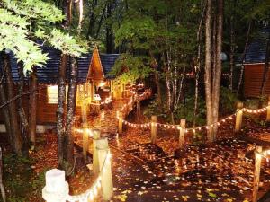 a house with lights in the forest at night at Stay In Biei in Biei