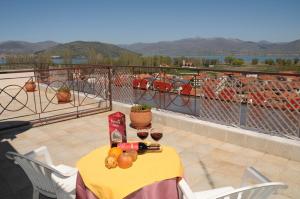 カストリアにあるDimitra Guesthouseのバルコニーにテーブルとフルーツ、ワインを用意しています。