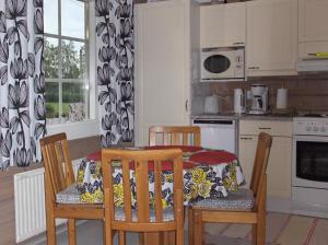 a kitchen with a table and two chairs and a kitchen with a table and chairs at Silfvastas Holiday Homes in Lapinjärvi